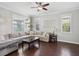 Bright living room with hardwood floors, a ceiling fan, and floating shelves at 8203 Interbay Blvd, Tampa, FL 33616