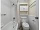Bright bathroom featuring a shower-tub combination, a decorative shower curtain, and a built-in wall cabinet at 11485 Oakhurst Rd # A301, Largo, FL 33774