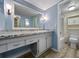 Light blue bathroom featuring an extended vanity with granite counters, a large mirror, and a shower-tub combination at 11485 Oakhurst Rd # A301, Largo, FL 33774