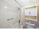 Bright bathroom featuring a shower-tub combination, a decorative shower curtain, and a built-in wall cabinet at 11485 Oakhurst Rd # A301, Largo, FL 33774
