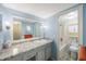 Light blue bathroom featuring an extended vanity with granite counters, a large mirror, and a shower-tub combination at 11485 Oakhurst Rd # A301, Largo, FL 33774