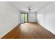 Bright bedroom features wood floors, a ceiling fan, and sliding glass doors to a balcony at 11485 Oakhurst Rd # A301, Largo, FL 33774