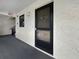 Condo front door with textured walls, neutral carpet, and small window offering natural light at 11485 Oakhurst Rd # A301, Largo, FL 33774