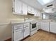 Kitchen showcasing white appliances, laminate countertops, and plenty of cabinet storage at 11485 Oakhurst Rd # A301, Largo, FL 33774