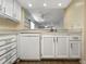 Kitchen with white cabinets, stainless steel sink, and a view to the living room at 11485 Oakhurst Rd # A301, Largo, FL 33774