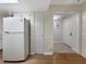 Kitchen area featuring white appliances, tile flooring, and access to the main hallway at 11485 Oakhurst Rd # A301, Largo, FL 33774