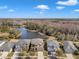 Aerial view of several homes near a tranquil lake surrounded by trees and a clear blue sky with clouds at 20209 Merry Oak Ave, Tampa, FL 33647