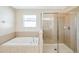Bathroom with a soaking tub, separate glass shower, and tiled walls at 20209 Merry Oak Ave, Tampa, FL 33647
