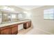 Bathroom featuring a granite countertop vanity with dual sinks, a large mirror and a glass shower at 20209 Merry Oak Ave, Tampa, FL 33647