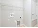 Clean laundry room with white walls, tile floors, wire shelving, and hookups for a washer and dryer at 20209 Merry Oak Ave, Tampa, FL 33647