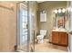 Bathroom with a tiled walk-in shower, wood vanity, and updated fixtures and decor at 4110 Huntingdale Ct, Wesley Chapel, FL 33543