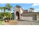 Inviting home featuring a two-car garage, well-maintained landscaping, and a stately arched entrance at 4110 Huntingdale Ct, Wesley Chapel, FL 33543