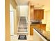 View of staircase leading to kitchen, granite countertops, and warm wood cabinetry at 4110 Huntingdale Ct, Wesley Chapel, FL 33543