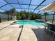 A luxurious screened pool and jacuzzi with a firepit feature for outdoor relaxation and entertainment at 4110 Huntingdale Ct, Wesley Chapel, FL 33543