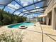 Luxury outdoor pool with spa, screened enclosure, patio, and lush landscaping for privacy and relaxation at 4110 Huntingdale Ct, Wesley Chapel, FL 33543