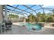 A luxurious screened pool and jacuzzi with swim up seating and a built in table for outdoor relaxation at 4110 Huntingdale Ct, Wesley Chapel, FL 33543