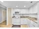 Clean kitchen with white cabinets, white appliances, and stone counter tops at 800 S Gulfview Blvd # 403, Clearwater Beach, FL 33767