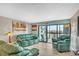 Spacious living room filled with comfortable green couches, a chair, and a view out to the balcony at 800 S Gulfview Blvd # 403, Clearwater Beach, FL 33767