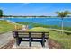 Scenic lake view with bench seating, lush landscaping, and a tranquil waterfront atmosphere in a lakeside community at 8326 Fantasia Park Way, Riverview, FL 33578