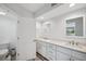 Bright bathroom featuring white cabinets, double sinks, and a large mirror at 960 Starkey Rd # 10301, Largo, FL 33771