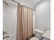 Clean bathroom featuring shower with beige curtain, toilet, and white subway tiles at 960 Starkey Rd # 10301, Largo, FL 33771