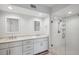 Modern bathroom featuring double sinks, white cabinetry, and a glass-enclosed shower with subway tile at 960 Starkey Rd # 10301, Largo, FL 33771