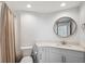Clean bathroom with a round mirror, shower with curtain, and modern fixtures at 960 Starkey Rd # 10301, Largo, FL 33771