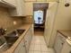 Galley kitchen showcasing white cabinets and stainless-steel sink at 1235 S Highland Ave # 3-303, Clearwater, FL 33756