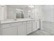 Bathroom with double sink vanity, white cabinets and shower at 1255 Kazaz Ct, Zephyrhills, FL 33540