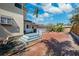 Paver driveway with blue stairs leads to the door and garage, surrounded by lush landscaping at 1370 Brightwaters Ne Blvd, St Petersburg, FL 33704