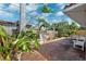 Brick patio surrounded by lush tropical plants and a wooden fence, creating a serene backyard retreat at 1370 Brightwaters Ne Blvd, St Petersburg, FL 33704