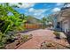 Expansive brick patio with a wooden fence and lush tropical landscaping; perfect for outdoor entertaining at 1370 Brightwaters Ne Blvd, St Petersburg, FL 33704
