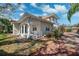 Exterior view of a charming home featuring a brick walkway, columns, and lush landscaping at 1370 Brightwaters Ne Blvd, St Petersburg, FL 33704