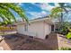 Charming home exterior with a brick patio, bench, and lush tropical foliage for a private oasis at 1370 Brightwaters Ne Blvd, St Petersburg, FL 33704