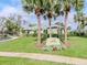 Club Grand Oaks sign surrounded by manicured landscaping and mature palm trees on a sunny day at 25925 Terrawood Loop, Land O Lakes, FL 34639