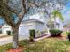 Two-story home featuring an attached garage, a well-maintained lawn, landscaping and a walkway to the front door at 25925 Terrawood Loop, Land O Lakes, FL 34639