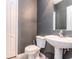 Modern half bath featuring gray walls, white fixtures, and neutral tile flooring at 25925 Terrawood Loop, Land O Lakes, FL 34639