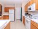 Bright kitchen with wooden cabinets, white appliances, ample counter space and tiled floor at 25925 Terrawood Loop, Land O Lakes, FL 34639