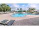 Community pool with lounge chairs, umbrellas and a fenced surround on a bright sunny day at 25925 Terrawood Loop, Land O Lakes, FL 34639