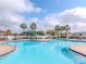 Large community pool surrounded by palm trees, lounge chairs and a covered pavilion area at 25925 Terrawood Loop, Land O Lakes, FL 34639