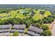 Scenic aerial view of townhomes near the lush, green golf course and pond at 3151 Landmark Dr # 123, Clearwater, FL 33761
