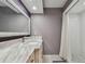Well-lit bathroom with a marble countertop, decorative mirror, and tiled shower with curtain at 3151 Landmark Dr # 123, Clearwater, FL 33761