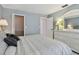 Comfortable bedroom featuring serene color palette, white furnishings, closet, and open doorway at 3151 Landmark Dr # 123, Clearwater, FL 33761