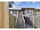 Charming condo featuring gray fencing, lovely entryway steps, and a cozy second story balcony at 3151 Landmark Dr # 123, Clearwater, FL 33761