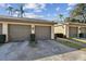 Attached two-car garage of a home with lush green landscaping at 3151 Landmark Dr # 123, Clearwater, FL 33761