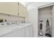 Bright laundry room with white washer, dryer, storage cabinets and closet for organizing cleaning supplies at 3151 Landmark Dr # 123, Clearwater, FL 33761