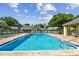 Community pool featuring a tanning ledge, lounge chairs, and a covered patio at 3151 Landmark Dr # 123, Clearwater, FL 33761