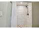 Walk-in shower with stone floors and white tiled walls at 3151 Landmark Dr # 123, Clearwater, FL 33761