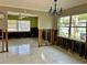 Spacious living room featuring tile flooring, large windows and a modern blue chandelier, awaiting renovation at 346 80Th Ne Ave, St Petersburg, FL 33702