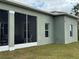 View of the rear of the house, including the screened lanai, stucco exterior, and well maintained lawn at 493 Omen St, Punta Gorda, FL 33982